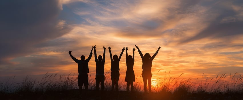 The silhouettes of friends celebrating at sunset in a scenic landscape. photo