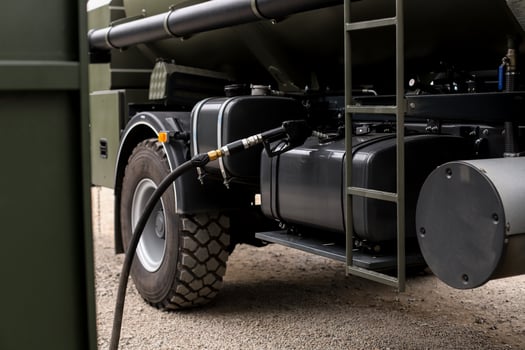 A military refueling vehicle stands at a gas station photo
