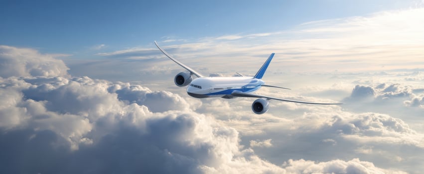 The airplane soaring above clouds in a bright blue sky. photo