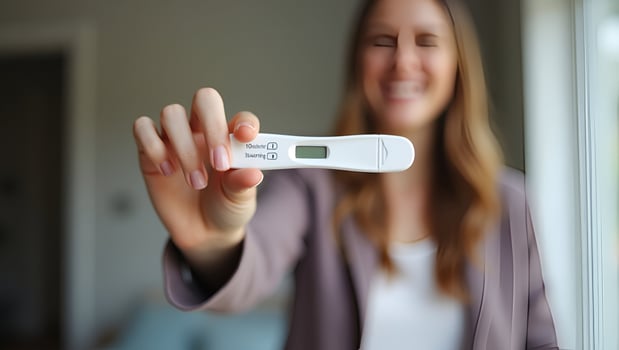 Young woman holding pregnancy test in hand depicting pregnancy confirmation and emotional moment in personal setting concept as Young woman holding pregnancy test in hand depictin Act photo
