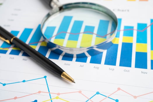 Magnifying glass on graphs with pen photo