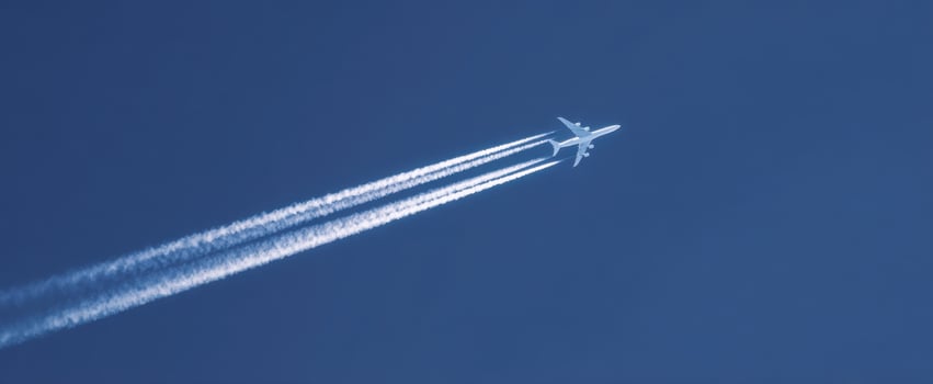 The airplane soaring high above the clear blue sky leaving white contrails. photo