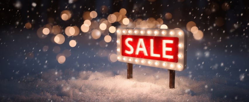 The illuminated sale sign in a snowy winter landscape with festive lights. photo
