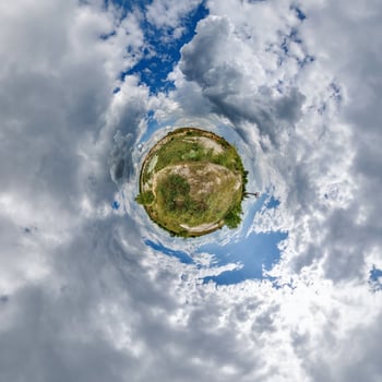 A small planet with clouds and sky in the background photo