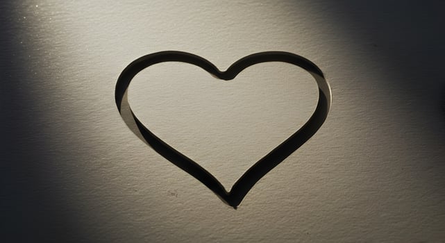 Heart shaped cutout on textured paper with soft light and shadow effects photo