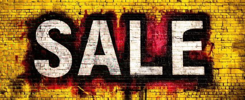 The expressive SALE graffiti on a vibrant yellow brick wall photo