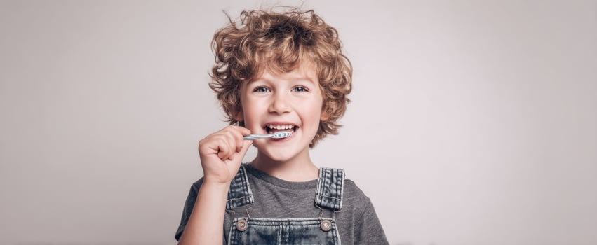 The cheerful child brushing teeth with enthusiasm and joy. photo