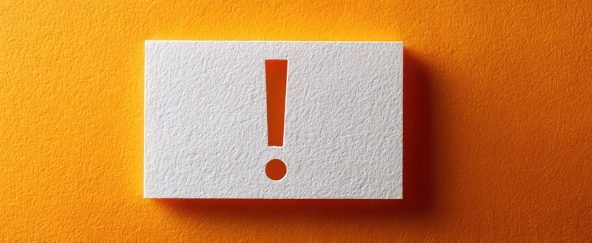 The exclamation mark on a textured white card against an orange background. photo