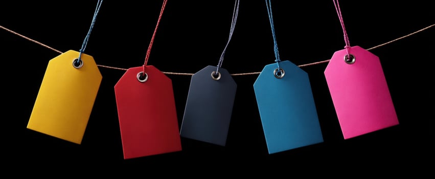 The colorful tags hanging on a string against a black backdrop. photo