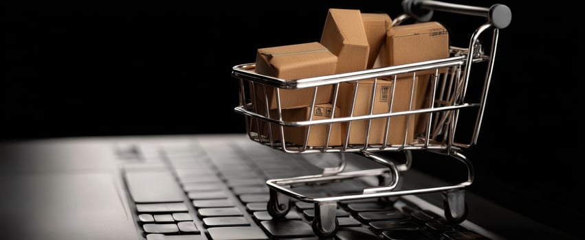 The shopping cart filled with parcels on a laptop keyboard. photo