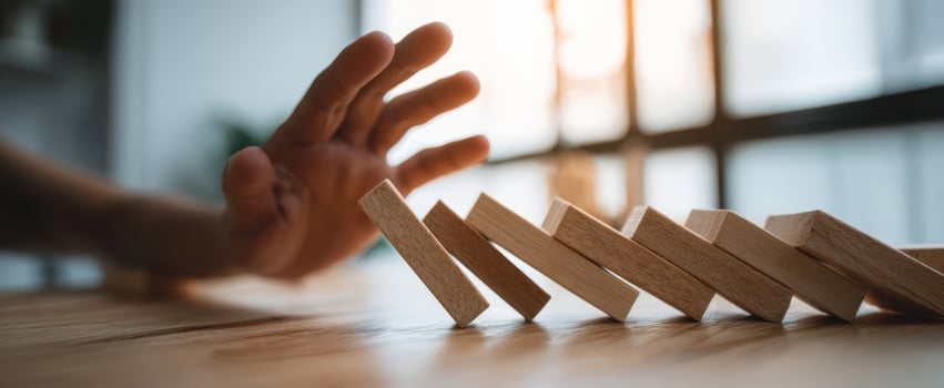 The Hand Preventing Dominoes from Falling in a Business Setting photo