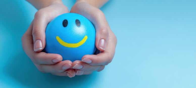 The Smiley Stress Ball Held Gently in Caring Hands Symbolizing Comfort and Wellbeing photo