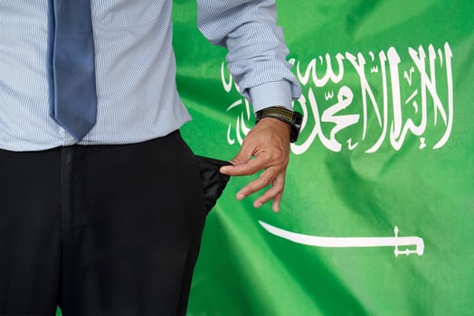 Man turns up his trouser pocket on the background of the Saudi arabia flag photo