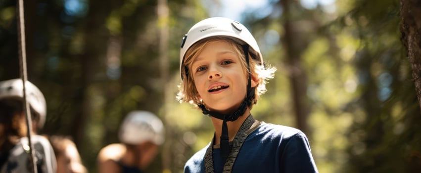 The Boy with Helmet Smiling on a Forest Ropes Course During Sunny Outdoor Adventure photo