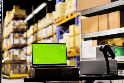 Modern warehouse facility featuring isolated workstation with chroma key display, surrounded by racks and delivery tools for e-commerce, order fulfillment and cargo boxes movement. photo