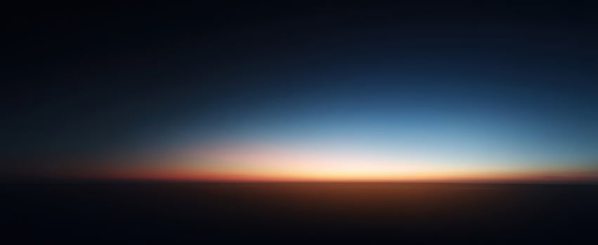 The Horizon at Dawn with a Thin Band of Golden Light Above Dark Clouds photo