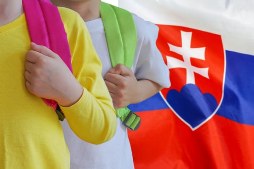 Two children with satchels background of Slovakia flag photo