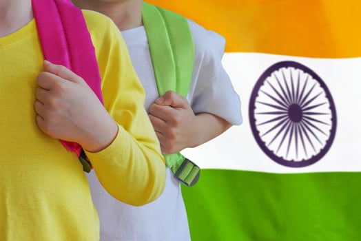 Two kids with satchels background of India flag photo