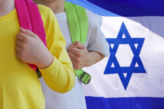 Two kids with satchels background of Israel flag photo
