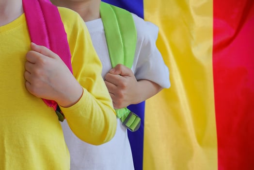 Two children with satchels background of Moldavia flag photo