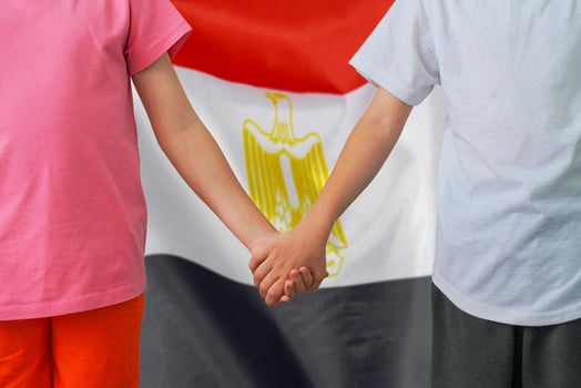 Boy and girl joined hands on background flag of Egypt photo