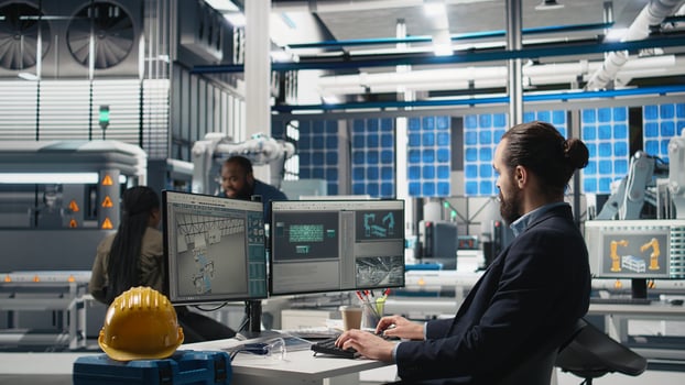 Professional inspector reviewing manufacturing process data on computer, ensuring seamless solar panels production in the photovoltaics factory. Expert works on renewable energy. Camera A. photo