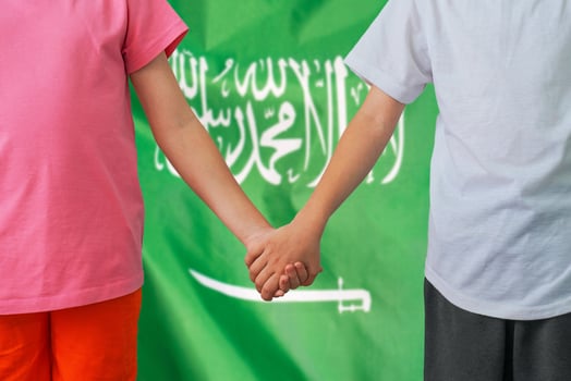Boy and girl joined hands on background flag of Saudi arabia photo