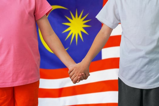 Boy and girl joined hands on background flag of Malaysia photo