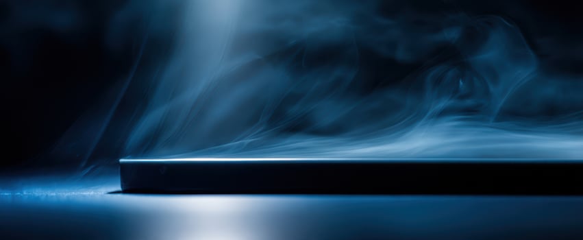The smartphone on a reflective surface with swirling blue smoke and dramatic lighting photo