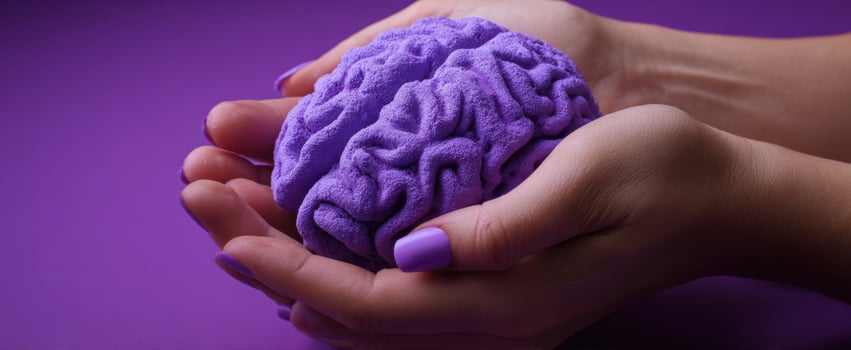 The Brain Held in Hands Against a Vibrant Purple Background Evoking Creativity and Care photo