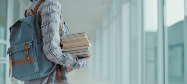 The Student Carrying Textbooks and Wearing a Backpack in a Bright Modern Hallway photo
