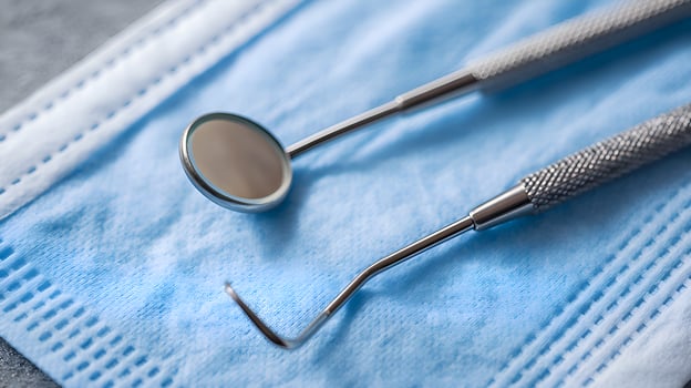 Dental instruments lying on protective face mask promoting oral hygiene photo