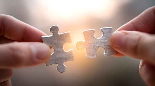 Two hands joining puzzle pieces with sunlight background photo