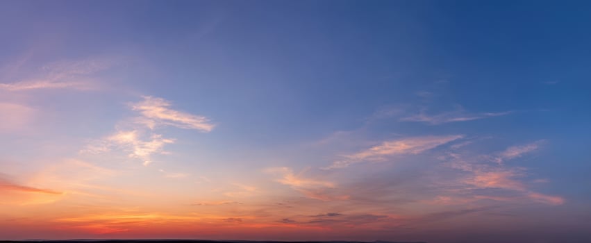 The Sky at a Colorful Sunset with Soft Clouds over a Calm Horizon photo