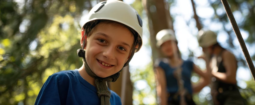 The Boy in a Helmet Smiling on an Outdoor Ropes Course with Friends photo
