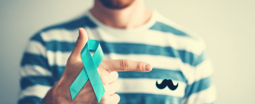 The Man Pointing to a Teal Ribbon on a Striped Shirt for Health photo