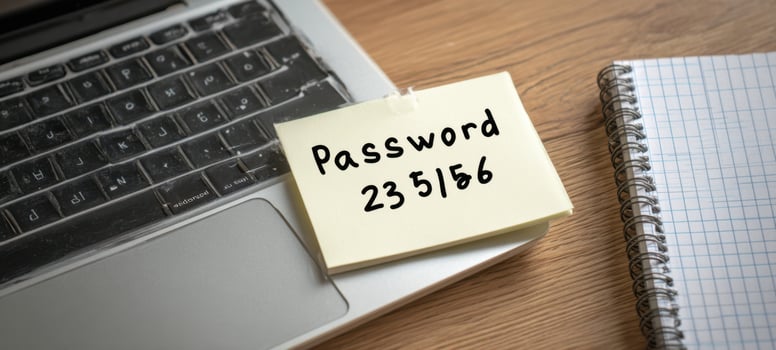 The Sticky Note With Password Resting On Laptop Trackpad And Notebook On Wooden Desk photo