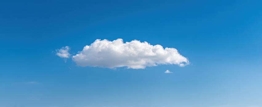 The cloud floating as a solitary white cumulus across a bright clear blue sky photo