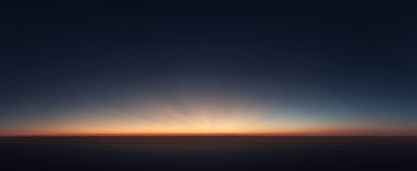 The Horizon at Dawn with Radiant Light Rays and Calm Ocean Panorama photo