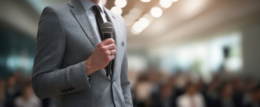 The speaker holding a microphone at a business conference in front of audience photo
