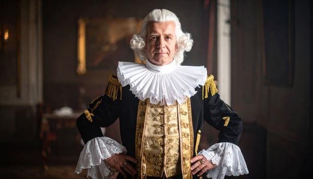 An older man in a costume poses for a photo