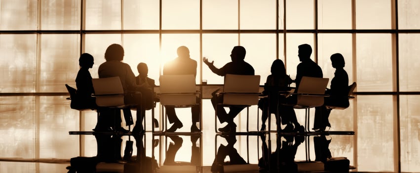 The Boardroom Meeting of Silhouetted Executives Around a Backlit Conference Table at Sunrise photo