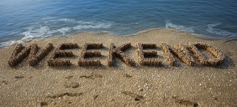 The Weekend Word Sculpted from Driftwood on a Sunny Sandy Beach Shoreline photo