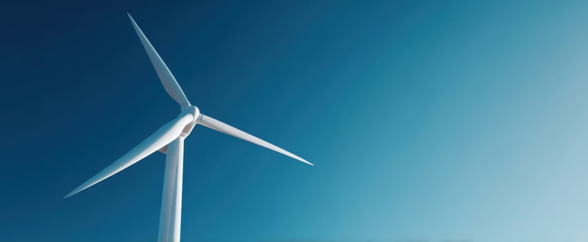 The Wind Turbine Standing Tall Against a Clear Blue Sky at Sunrise photo