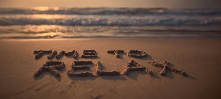 The Time to Relax message written in sand on a serene sunset beach photo