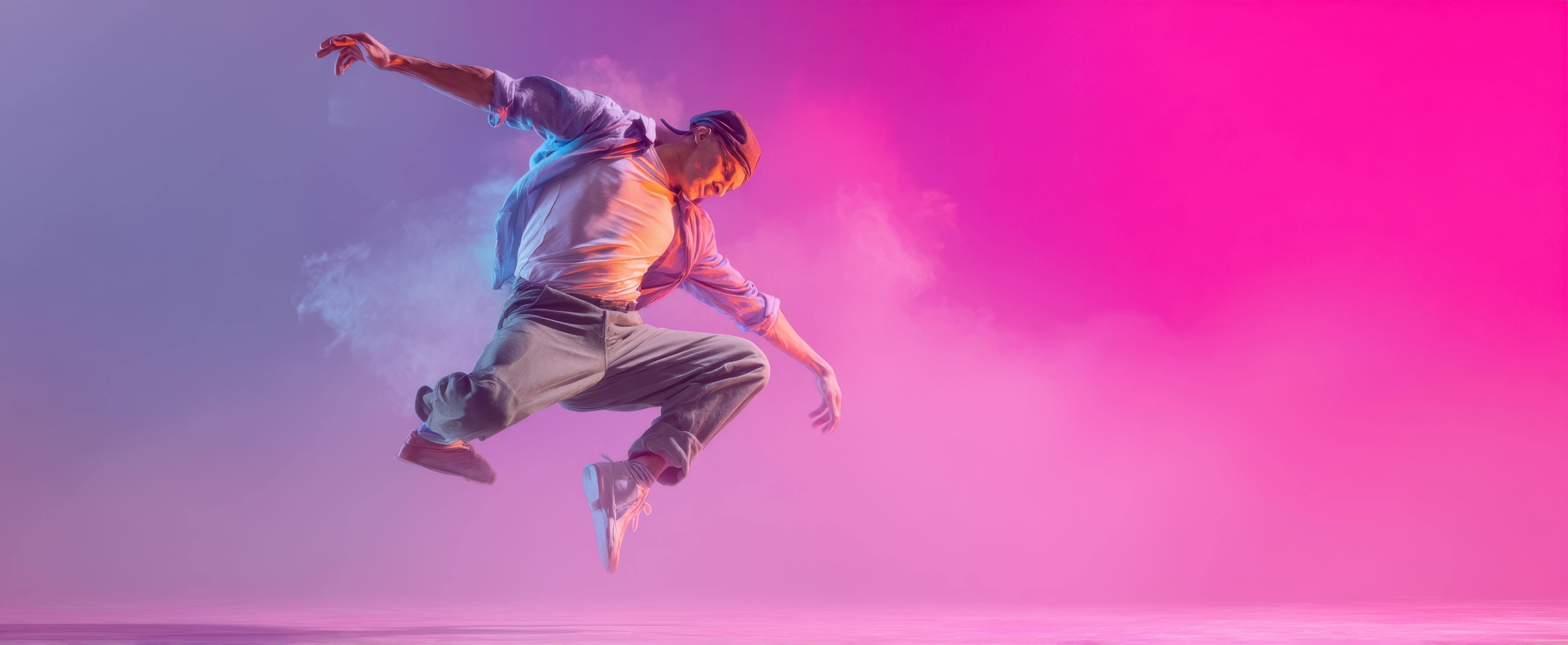 The dancer leaping across a neon pink and blue studio with dynamic airborne pose photo