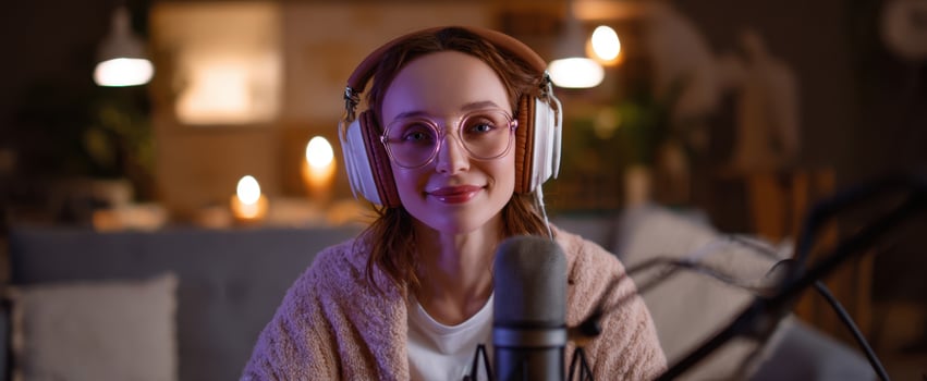The young woman recording a cozy evening podcast with headphones and microphone photo