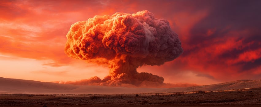 The Mushroom Cloud Rising Over a Barren Desert During a Fiery Sunset photo