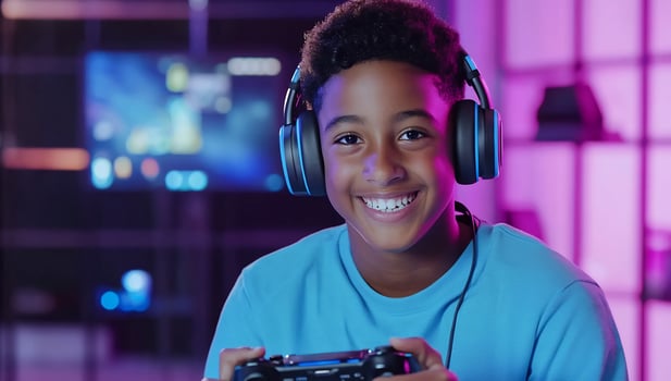 Happy boy gaming, neon room, joyful expression, screen background, website banner photo
