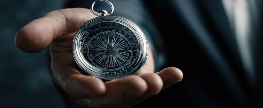 The Compass in a Businessman's Hand Symbolizing Guidance, Direction and Leadership photo